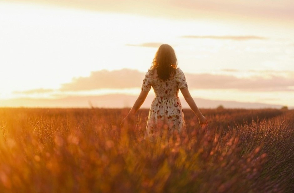Immagine rilassante di una donna che passeggia in un campo di lavanda al tramonto, ad indicare la durata della psicoterapia per l'ansia e la progressiva risoluzione del disturbo