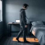 Giovane adulto con cuffie cammina avanti e indietro in una stanza, immagine sfocata che rappresenta il maladaptive daydreaming
